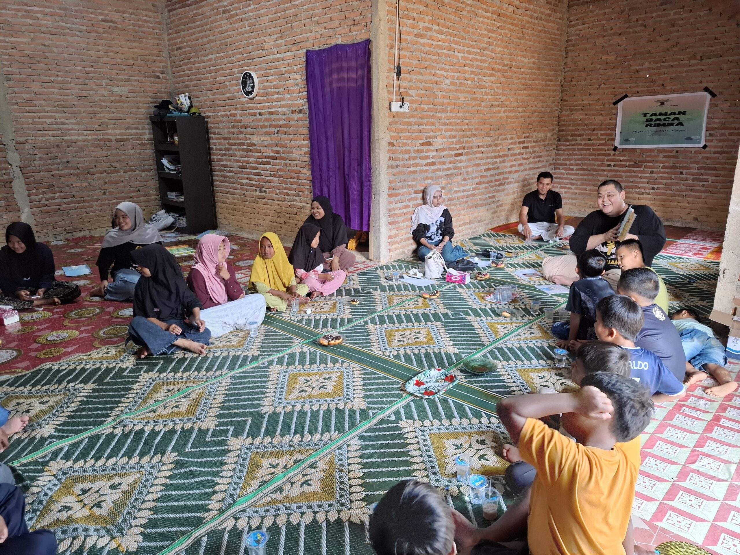 Dr. Amar Salahuddin membacakan buku untuk anak-anak di ruangan Taman Baca Rimba Dharmasraya