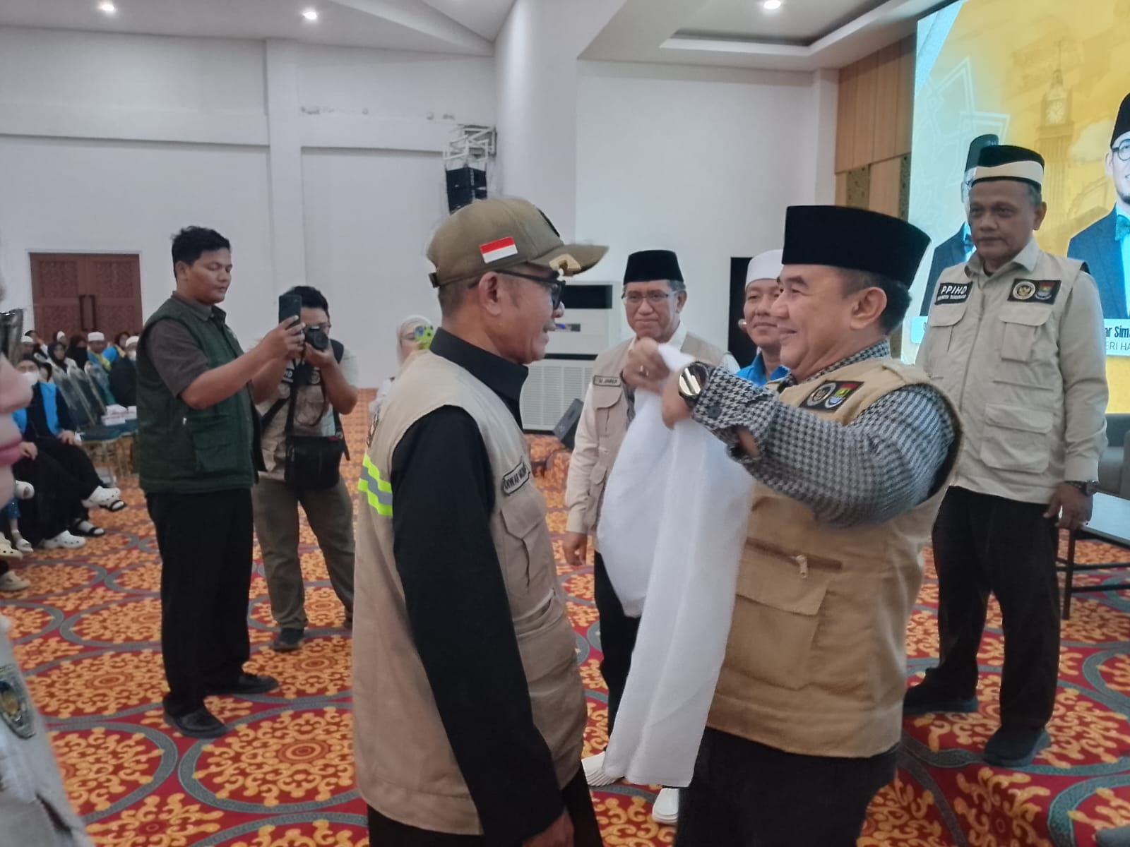 Sekda Kabupaten Tangerang Soma Atmaja mengalungkan kain putih selamat datang kepada jamaah haji Kloter 12 JKB asal Kabupaten Tangerang di Asrama Haji Provinsi Banten Cipondoh Rabu 17 Juni 2026