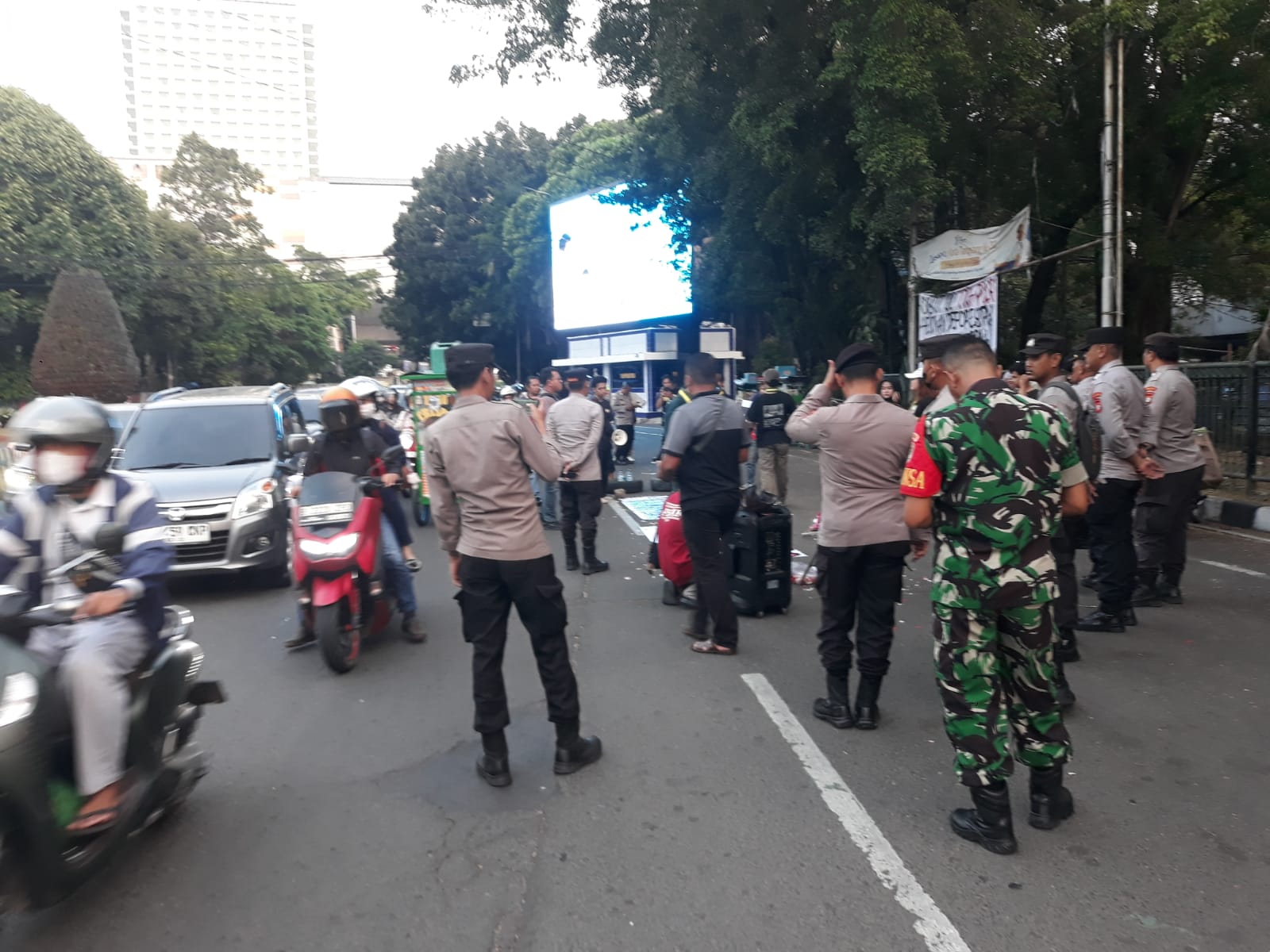 Anggota Polsek Tangerang dan TNI berjaga dan mengatur arus lalu lintas saat aksi demonstrasi mahasiswa di depan Taman Gajah Kota Tangerang
