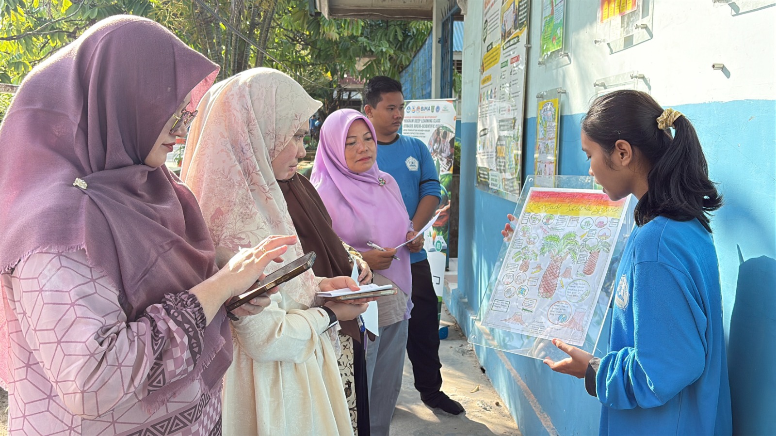 Siswa-siswi SMAN 2 Siak Hulu berseragam biru berdiskusi aktif di depan Papan Edukatif SSI bertuliskan Isu Ilmiah Bukti Ilmiah Dampak Sosial Alternatif Keputusan dengan kartu-kartu tempel berwarna saat pembelajaran Deep Learning oleh Dosen UIR