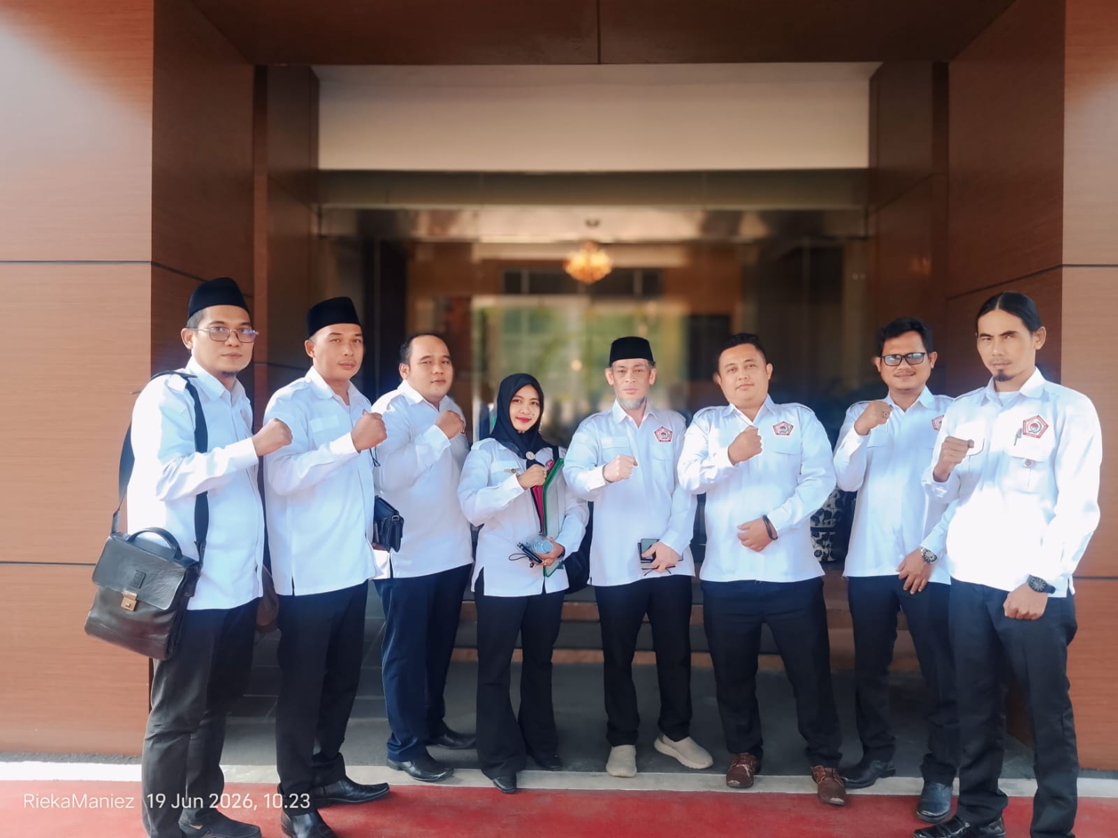 Delapan pengurus DPW GMPK Banten dan DPD GMPK Kabupaten Tangerang memakai seragam putih berlogo GMPK berpose mengepalkan tangan di depan Gedung Kejari Kabupaten Tangerang sebelum audiensi pada 19 Juni 2026