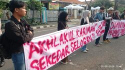 Mahasiswa CGMT membentangkan spanduk bertuliskan Akhlaqul Karimah saat aksi demo di depan Kantor Kecamatan Tangerang