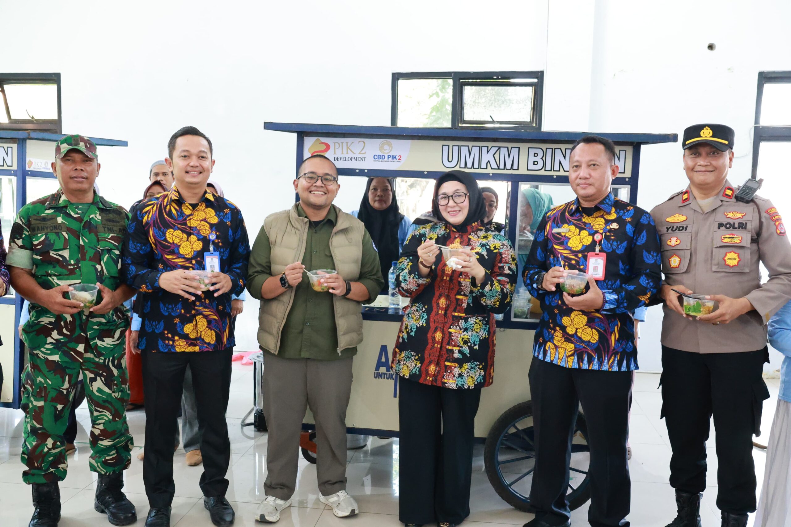 Wabup Intan bersama Forkopimcam Kronjo memegang mangkok mie ayam di depan gerobak UMKM