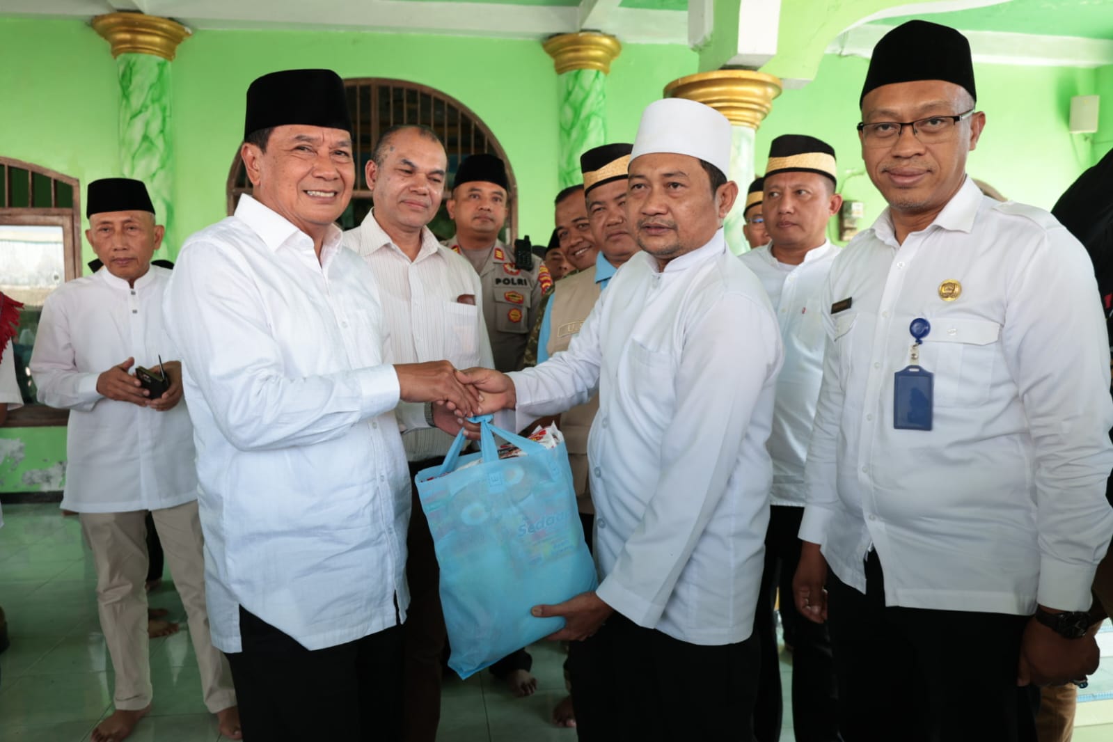 Bupati Tangerang Moch Maesyal Rasyid bersalaman dan menyerahkan paket sembako tas biru kepada pengurus masjid di Masjid Darurrohman Rajeg didampingi pejabat Pemkab Tangerang