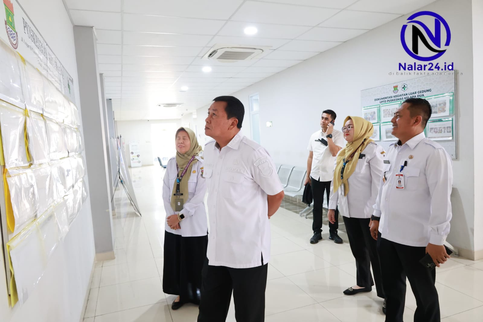 Bupati Maesyal bersama petugas Puskesmas melihat papan dokumentasi kegiatan di Puskesmas Kelapa Dua
