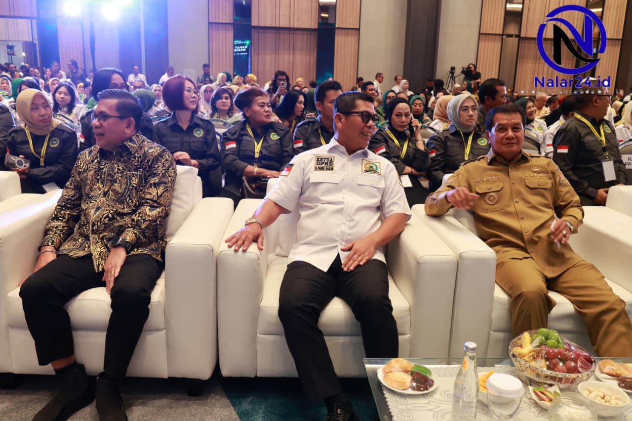 Tiga orang pria duduk di sofa putih di acara pertemuan dengan meja berisi buah dan makanan di depannya