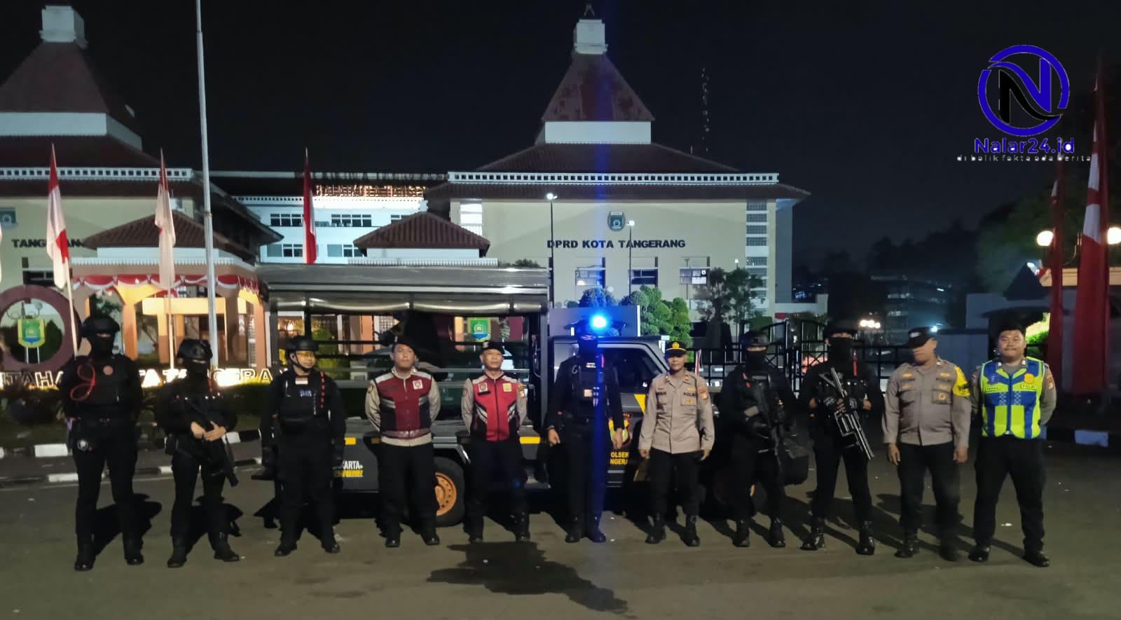 Barisan personel polisi dan brimob berpose bersama di depan gedung DPRD Kota Tangerang pada malam hari