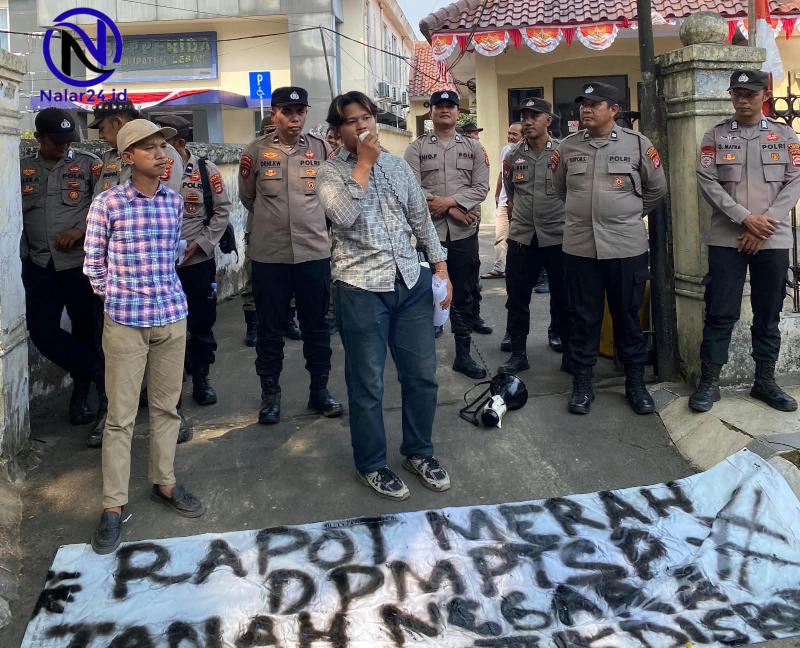 Koordinator BMAP berorasi di depan kantor dengan spanduk bertuliskan rapot merah DPMPTSP