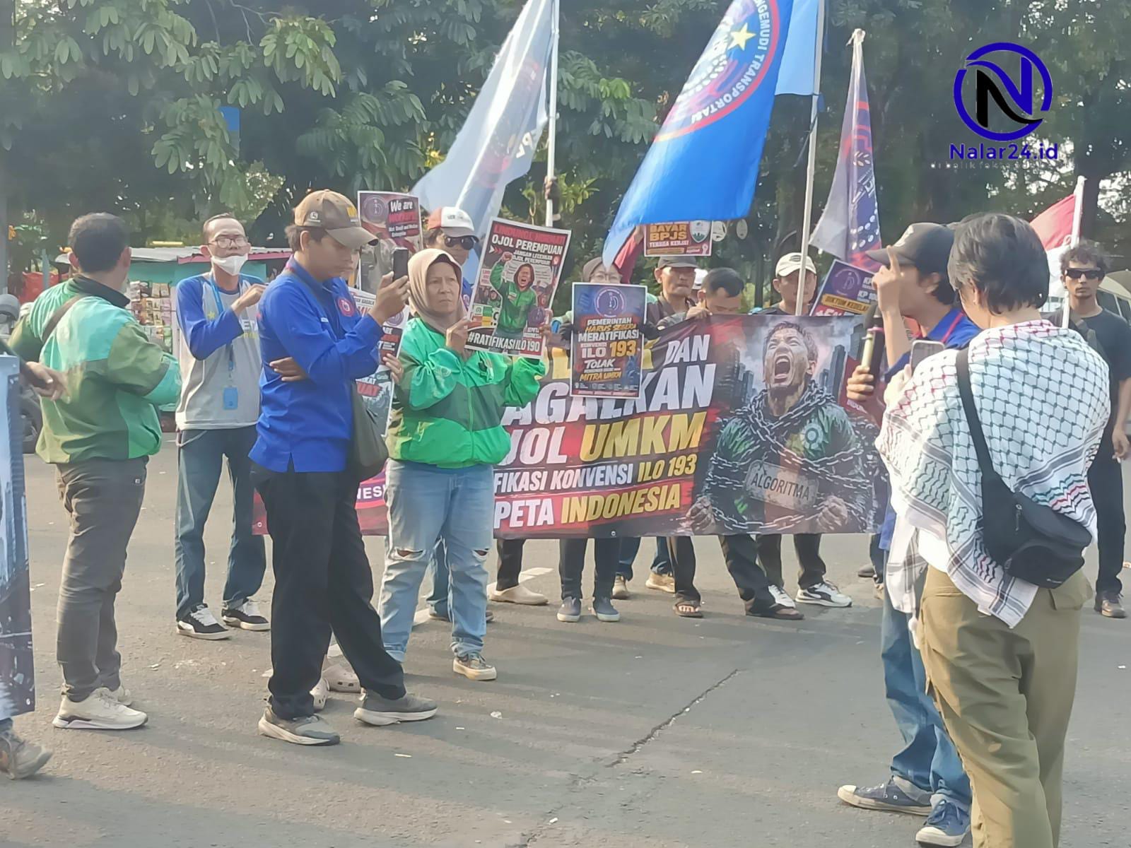 Driver membawa spanduk saat berorasi