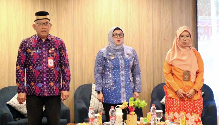 Wakil Bupati Tangerang berdiri bersama dua narasumber perempuan di depan meja acara