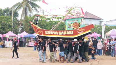 Warga Desa Surya Bahari mengarak miniatur kapal nelayan bertuliskan Surya Bahari saat Pesta Nelayan 2026 di Pakuhaji Kabupaten Tangerang