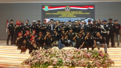Foto bersama puluhan anggota PPBNI Satria Banten DPC Kota Tangerang di atas panggung setelah Musyawarah Cabang I. Peserta memakai seragam hitam dengan latar layar bertuliskan Muscab I PPBNI dan hiasan bunga,