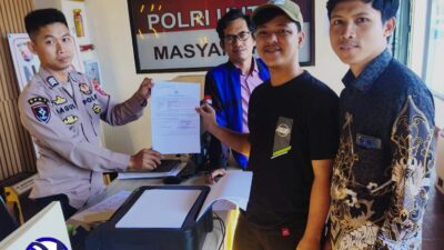 Kuasa hukum dan pelapor tunjukkan bukti laporan di kantor polisi