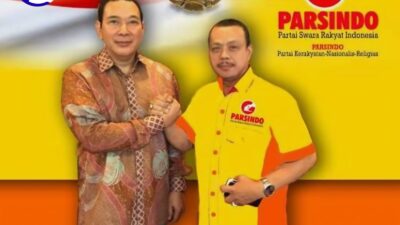 Tommy Soeharto dan Ketum Parsindo Jusuf Rizal berjabat tangan dengan latar bendera Merah Putih dan Garuda
