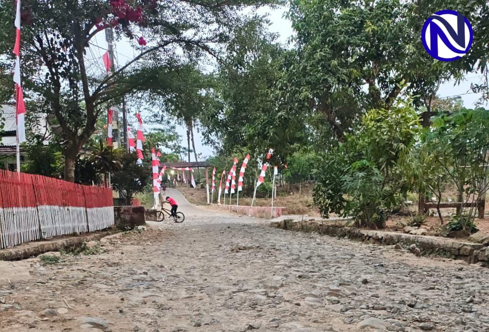 Anak mendorong sepeda di jalan berbatu rusak Desa Sukajadi Pandeglang
