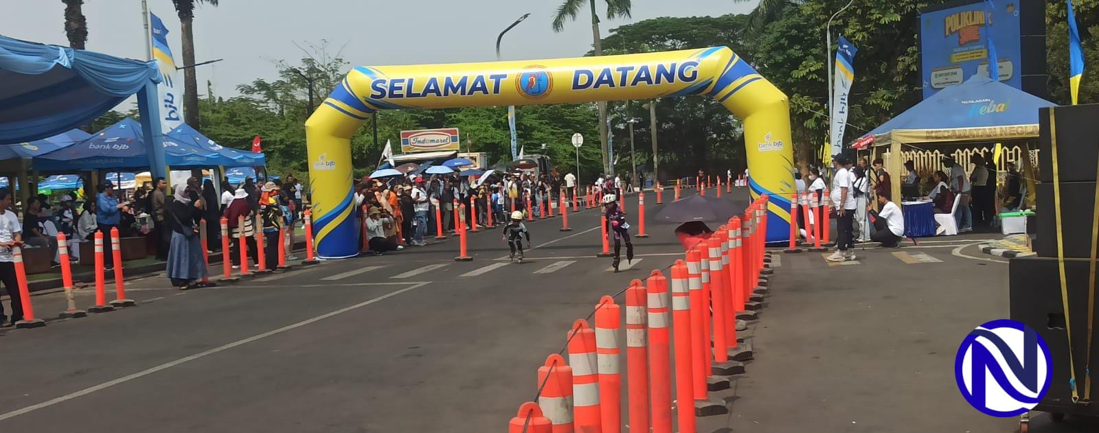 Dua atlet muda kategori pemula melesat di bawah gerbang balon bertuliskan SELAMAT DATANG