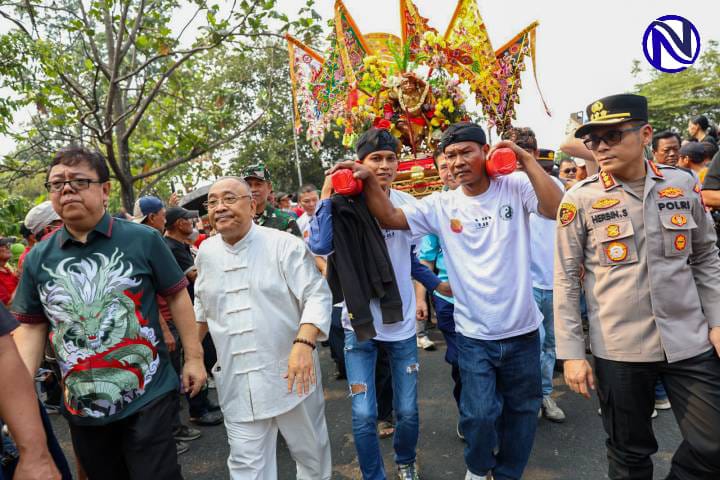 Peserta memikul joli tandu suci dalam Kirab Budaya Vihara Dhamma Budhi Bhakti Kota Tangerang dikawal Polisi